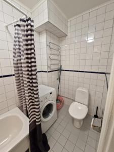 a bathroom with a washing machine and a toilet at Home Inn VMG in Stockholm