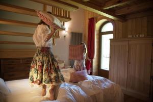a woman standing on a bed with a hat on her head at Albergo Monte Cervino in Champoluc