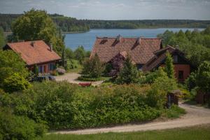 a group of houses with a lake in the background at Lipowy dom in Piecki
