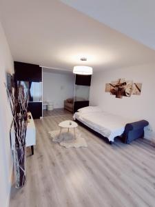 a bedroom with a large bed and a table at Happy Blue Apartament in Galaţi