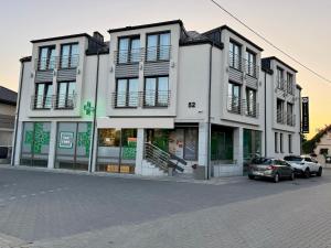 a white building with cars parked in front of it at Villa Nova in Białystok