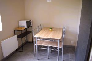 einen Tisch und Stühle in einem kleinen Zimmer mit einer Mikrowelle in der Unterkunft Studio 2 personnes in Saint-Amand-sur-Sèvre + 1 Foto