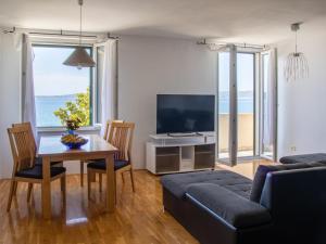 a living room with a table and a couch and a television at Sea View Apartment No3 Kaštela in Kaštela