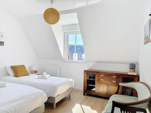 a bedroom with two beds and a desk and a chair at Le Victorien YourHostHelper in Deauville +16 photos