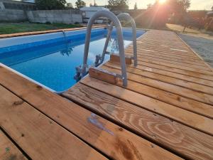 a wooden deck next to a swimming pool at Apartamenty Welskie in Lidzbark