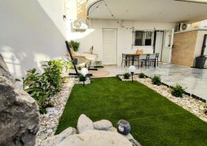 a backyard with a small yard with grass and rocks at Casa Di Penny 1 in Kyparissia