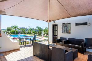 een patio met een tafel en stoelen en een zwembad bij Solgarve in Quarteira