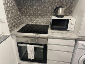 a kitchen with a stove and a microwave at Villa Do Calo in Sagres