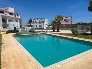 a large blue swimming pool in front of a building at Villa Do Calo in Sagres