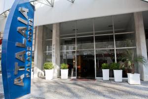 ein Gebäude mit Topfpflanzen davor in der Unterkunft Atalaia Palace Hotel in Guarapuava