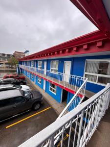a blue building with cars parked in a parking lot at Capone's Hideaway Motel in Moose Jaw