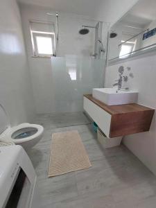 a white bathroom with a sink and a toilet at Apartments Mišković in Vir +9 photos