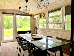 a dining room with a table and chairs and windows at DOMEGLAMPING at FISHINGLAKE in Ságvár
