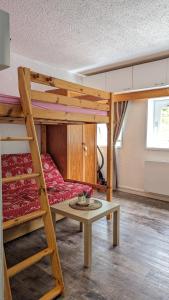 a room with a bunk bed and a table at Studio avec linge de maison fourni et tout équipé aux pieds des pistes in Villard-de-Lans