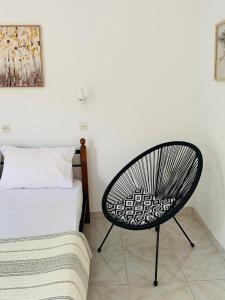 a bedroom with a chair next to a bed at Skopelos Inn in Stafylos