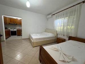 two beds in a room with a kitchen at Uzeiri’s Houses in Borsh