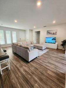 una gran sala de estar con sofás y TV de pantalla plana. en Palm Coast 3br 2ba beach home, en Palm Coast