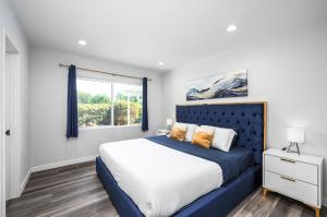 ein Schlafzimmer mit einem blauen Bett und einem Fenster in der Unterkunft Luxury 4 Bedroom House Mins to Disney! Game Room in Westminster