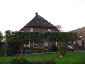 a large brick house with a thatched roof at Studio Het Grenspaaltje in Nijeveen