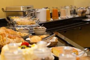 una línea de buffet con muchos tipos diferentes de comida en Atalaia Palace Hotel, en Guarapuava