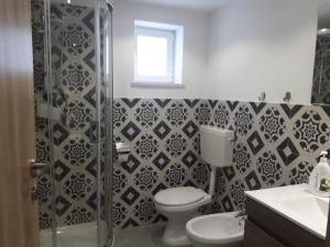 a bathroom with a toilet and a glass shower at VILLA MOGUNTIA in Ficarazzi