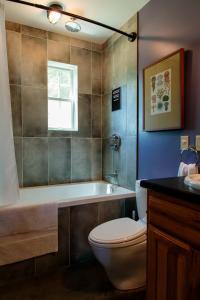Un baño con inodoro, bañera y lavabo. en Dwntwn home, Prvt Rooftop and Soaking Tub!, en Burlington