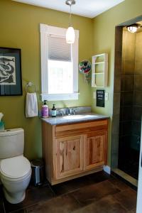 Un baño con inodoro, lavabo y ventana. en Dwntwn home, Prvt Rooftop and Soaking Tub!, en Burlington