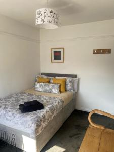 リバプールにあるLovely 2 Bed Full House By The Beachの黄色い枕が置かれたベッドのある寝室