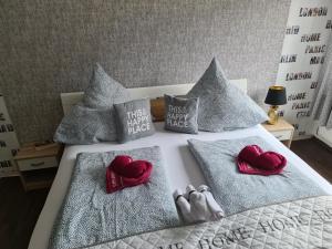 a bed with two pillows with red hearts on it at Schöne 3 Zimmer Wohnung in Oberwesel