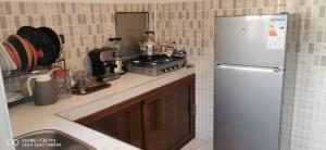 eine Küche mit Kühlschrank und Herd in der Unterkunft Appartement Proche plage Bouznika Bouznika in Bouznika + 12 Fotos