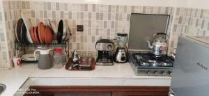 a kitchen counter with a coffee maker and a stove at Appartement Proche plage Bouznika Bouznika in Bouznika