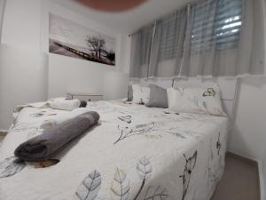 a bedroom with a large bed with a blanket on it at אחוזת עזרא בבני ברק in Bene Beraq