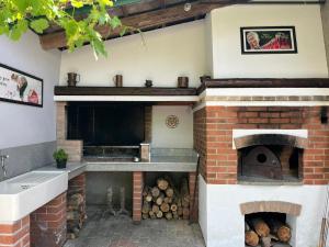 a kitchen with a brick oven with logs in it at Rouge Cottage nel Roero in Sanfrè
