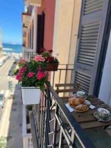 a table with bread and flowers on a balcony at Mariamora Apartment in Bari