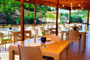a restaurant with tables and chairs and windows at Olive Branch Hotel in Ayvalık