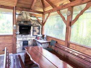 a dining room with a wooden table and a fireplace at Agroturystyka Wilkowyja in Mchawa