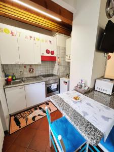a kitchen with white cabinets and a table with blue chairs at Holiday Treviso Suite Venezia in Treviso +5 photos