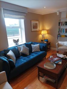 基拉尼的住宿－翠鳥旅館，客厅配有蓝色的沙发和桌子