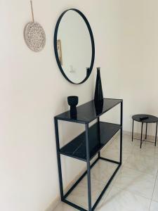 a black shelf with a mirror on a wall at Skopelos Inn in Stafylos