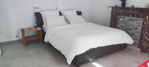 a bed with white sheets and pillows in a bedroom at Chambre R0 avec salle de bain partagée près de l'hôpital de la Citadelle à Liège in Liège