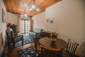 a living room with a table and chairs at Portal Flores Suítes in Campos do Jordão