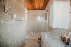 a bathroom with a shower and a toilet at Portal Flores Suítes in Campos do Jordão