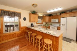 a kitchen with wooden cabinets and a white refrigerator at Ivy Falls by Eden Crest in Pigeon Forge