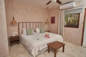 a bedroom with a bed with a hat on it at Villas Caracol in Holbox Island
