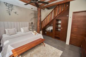 a bedroom with a large bed and a staircase at Villas Caracol in Holbox Island