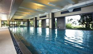 a large swimming pool with blue water in a building at Fleur de Chine Hotel in Yuchi