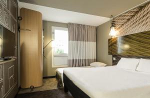 ヴァンヴにあるイビス パリ ヴァンヴ パルク デ エクスポジシオンの大きなベッドと窓が備わるホテルルームです。