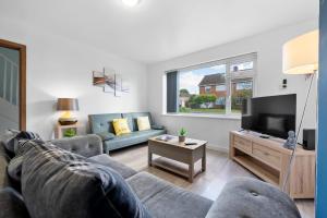 a living room with a couch and a tv at Legacy House - Secured Parking on Site in Tollbar End