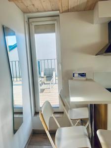 a room with a table and chairs and a balcony at Apartamentai su terasa in Palanga