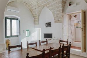 a dining room with a table and a tv at Dimora Lavinia Casa vacanze Centro storico Ostuni in Ostuni